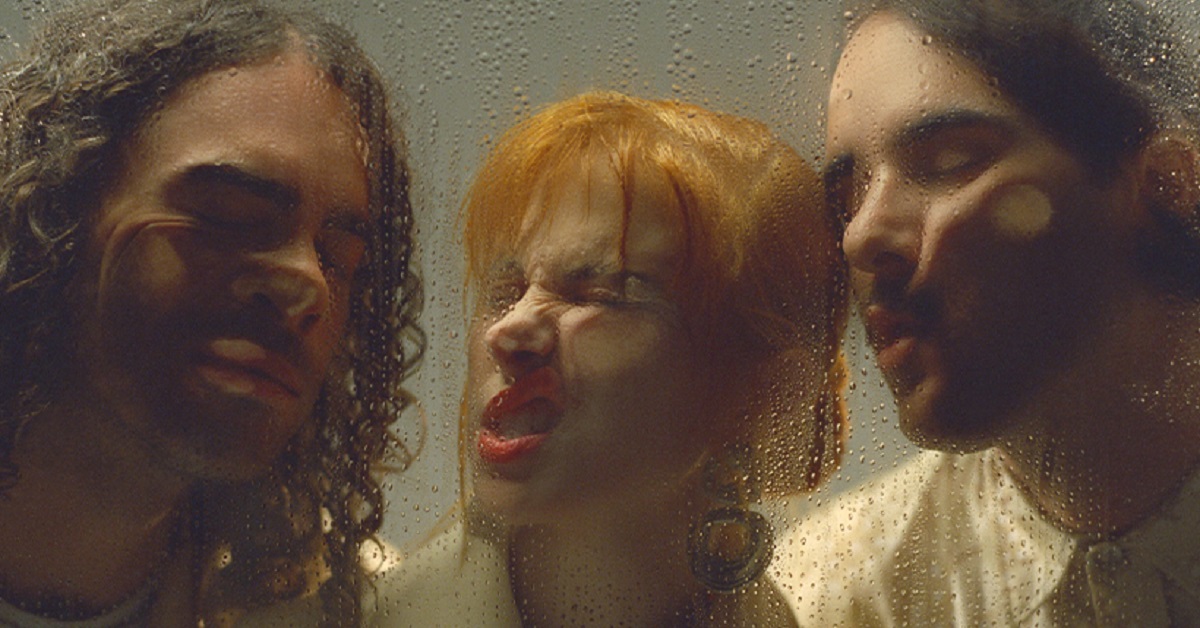 Paramore members with their faces pressed up against a glass wall