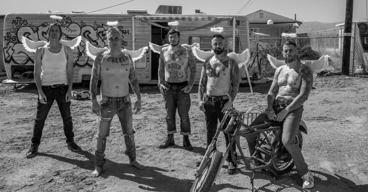 A photo of Avenged Sevenfold in a trailer park, they are wearing no tops and have wings on their back. 