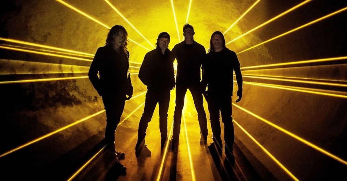 Metallica standing against a yellow and black backdrop 