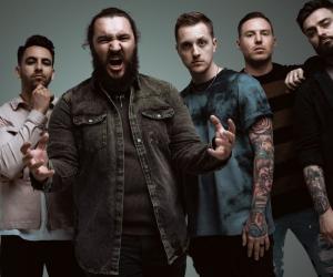 A photo of I Prevail standing against a charcoal background