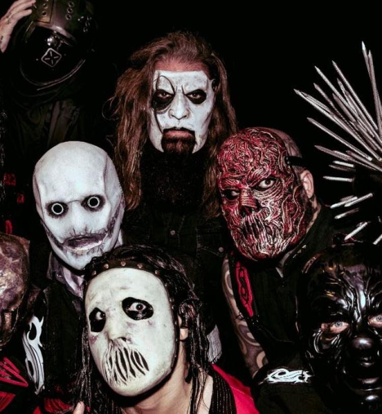 Photo of Slipknot wearing masks against a black background